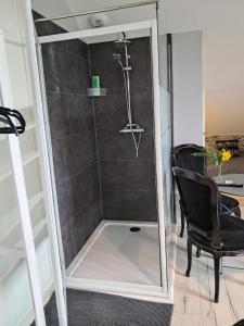 a shower with a mirror next to a chair at La Maison in Mirebeau-sur-Bèze +44 photos
