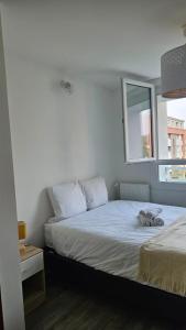 a bedroom with a bed and a window at T3 idéalement situé in Mérignac