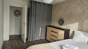 a bedroom with a bed and a dresser and a mirror at T3 idéalement situé in Mérignac