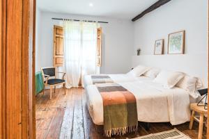 a bedroom with a large bed and a table at La Villa de Carla in Borleña