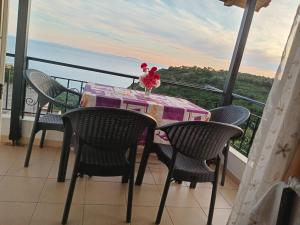 a table and chairs on a balcony with a view at Alban Apartament in Lukovë