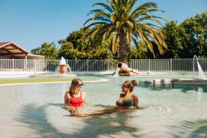 two women sitting in the water in a swimming pool at Camping Erreka in Bidart