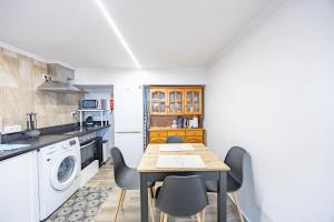 a kitchen with a table and chairs in a room at A Quintinha by YOUR KEY MADEIRA in Santa Cruz