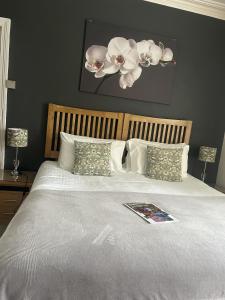 a bedroom with a large bed with white sheets and pillows at The Welford in Harrogate