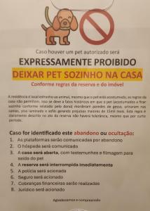 a sign with a dog and a no smoking sign at Suite Juede Platz - 02 - Centro de Pomerode in Pomerode