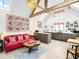a living room with a red couch and a table at 1 Bed in Ludlow oc-92768 in Hopton Cangeford