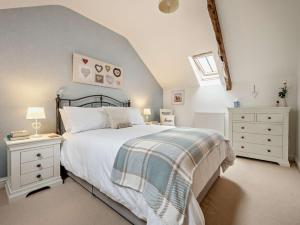 a bedroom with a bed and two dressers and a window at 3 Bed in Wigton oc-92826 in Torpenhow