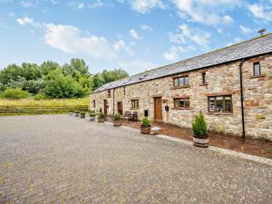 an old stone building with potted plants in front of it at 3 Bed in Wigton oc-92826 in Torpenhow