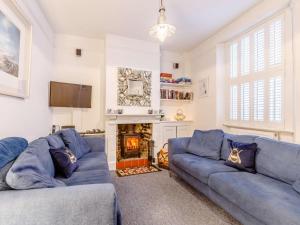 a living room with two blue couches and a fireplace at 3 Bed in Bideford oc-57804 in Appledore