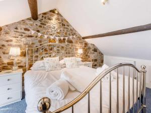 a bedroom with a bed and a stone wall at 3 Bed in Bideford oc-57804 in Appledore