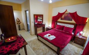 a bedroom with a large red bed with red pillows at Relax pozar in Kato Loutraki
