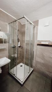 a shower with a glass door in a bathroom at Seehotel Sissi am Zeller See in Zell am See +60 photos