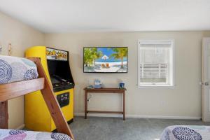 a bedroom with a bed and a desk and a game room at 5085 - Knapp's at the Beach in Kill Devil Hills