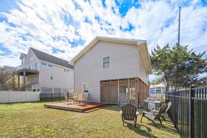 a backyard with a house and a fence at 5085 - Knapp's at the Beach in Kill Devil Hills