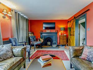 a living room with orange walls and a fireplace at 2 Bed in Spalding oc-91528 in Surfleet
