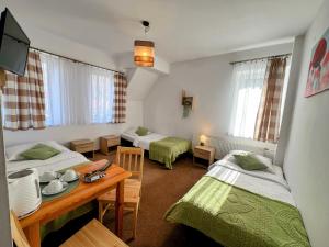 a small room with two beds and a table with a table at DW Bukówka in Karpacz