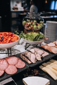 a table topped with different types of meat and vegetables at Quality Hotel Globe in Stockholm
