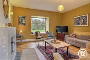 a living room with a couch and a table at Fontaine aman in La Roche-Jaudy