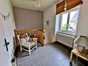 a room with a crib and a chair and a window at Villa SURF Situation exceptionnelle à 3 min à pied de la plage de Pors Carn Pour 5 personnes Authentique Bien équipée Jardin & BBQ Parking privatif in Penmarch