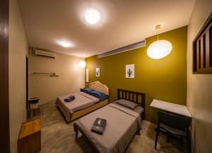 a room with two beds and a table and a desk at The Cottage Stay - self check-in in Kuching