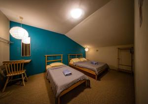 two beds in a room with a blue wall at The Cottage Stay - self check-in in Kuching