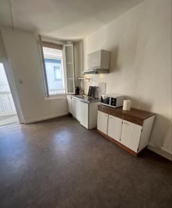 an empty room with a kitchen with a sink and a stove at Dortoir Entier Privatif in Tarbes