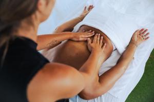 two women laying on a white bed with their hands on the stomach at Camping Erreka in Bidart