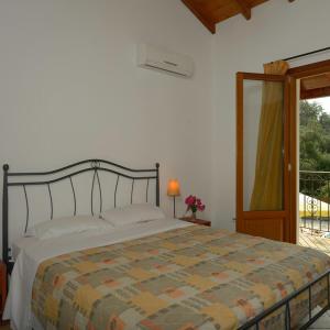 a bedroom with a bed and a door to a balcony at Villa Adrianna in Longós