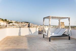 a hammock on a roof with a view of a city at B&B MATINE' Suits & Rooms in Matino