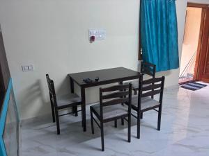 a black table and chairs in a room at Bhuvanavasigal alayam in Tiruvannāmalai
