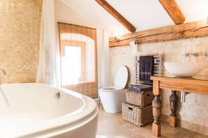a bathroom with a tub and a toilet and a sink at Tolmin center apartments Townhouse & Loft in Tolmin +68 photos