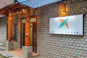 a sign on the side of a building at Zostel Homes Khajjiar in Chamba
