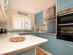 a kitchen with blue cabinets and a plate of food on a counter at 2 Bed in Brough oc-86817 in Scalby