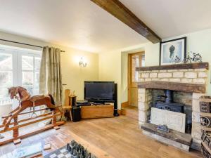 a living room with a fireplace and a horse statue at 4 Bed in Oakham oc-86556 in Empingham