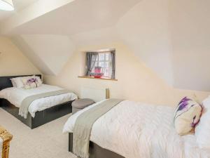 a attic bedroom with two beds and a window at 4 Bed in Oakham oc-86556 in Empingham +17 photos