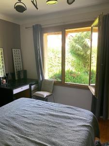 a bedroom with a bed and a desk and a window at Villa Crysaële in Menthon-Saint-Bernard +10 photos