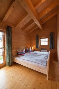 ein Schlafzimmer mit einem großen Bett in einem Holzhaus in der Unterkunft Pfenniggeiger-Hütte in Philippsreut