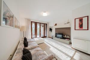 a living room with a couch and a flat screen tv at Villetta Le Scaje in Torri del Benaco