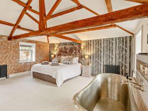 a bedroom with a bed and a bath tub at 3 Bed in Driffield oc-92697 in Lund