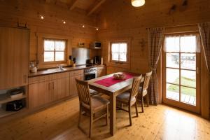 eine Küche mit einem Tisch und Stühlen in einer Hütte in der Unterkunft Pfenniggeiger-Hütte in Philippsreut