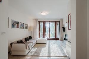 a white living room with a couch and a window at Villetta Le Scaje in Torri del Benaco +55 photos