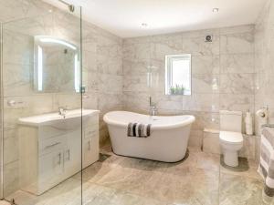 a bathroom with a tub and a sink and a toilet at 2 Bed in Malton oc-87936 in West Heslerton +14 photos