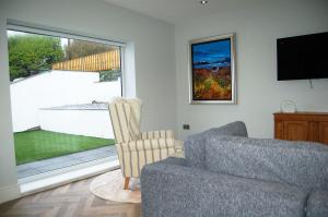a living room with a couch and a television at Morwendon House with Sea View in Llanaber