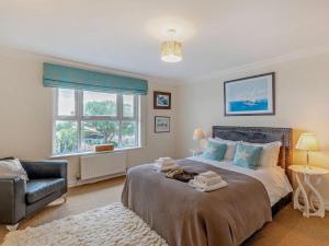 a bedroom with a bed and a chair and a window at 4 Bed in Bognor Regis oc-81446 in Bognor Regis +30 photos