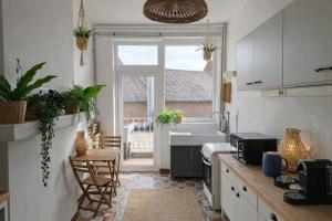 a kitchen with a sink and a table with chairs at Appartements Entiers - Centre de Tournai in Tournai