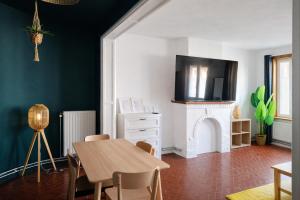 a dining room with a table and a fireplace at Appartements Entiers - Centre de Tournai in Tournai