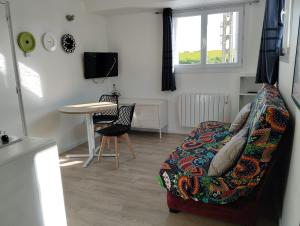 a living room with a couch and a table at Appartement a la Campagne in Radinghem-en-Weppes