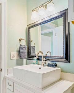 a bathroom with a white sink and a mirror at 4BR Near the BeachFire PitFamily Friendly Stay in Bolivar Peninsula +18 photos