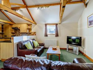 a living room with leather furniture and a tv at 2 Bed in Doncaster oc-93771 in Mattersey