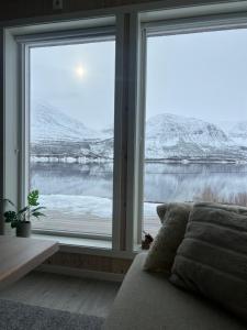 a bedroom with a large window with snow covered mountains at Ocean View Cottage in Alta